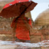 A Boy with a Red Umbrella poses in front of the Mosque at Lodhi Garden.